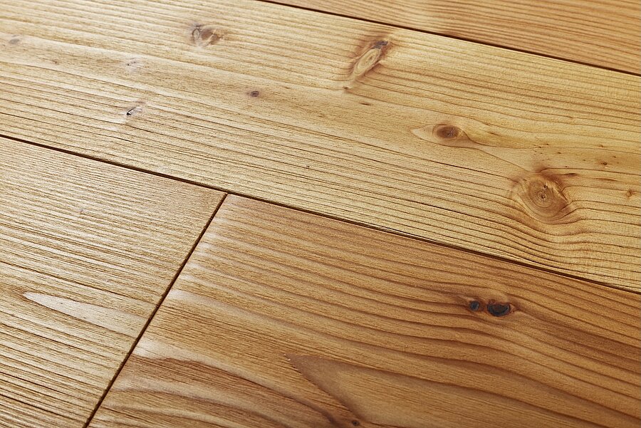Strukturierte Holzfläche aus Lärche mit sichtbaren Punktästen und geölter Naturfarboberfläche